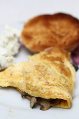 Omelette with fried champignon mushrooms  and toasted bread roll
