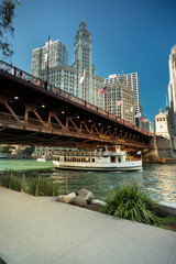 Ferry boat passes under the DuSable Bridge over the Chicago River in downtown Chicago Illinois USA during a summer day