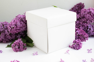 white gift box with lillac flowers. present