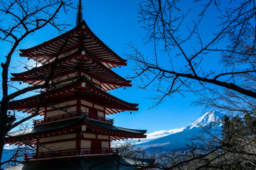 View on Chureito Pagoda and mountain of the mountains Mt Fuji, Japan captured on a clear, sunny day in winter. Top of the volcano covered with snow. Trees aren't blossoming yet. Postcard from Japan.