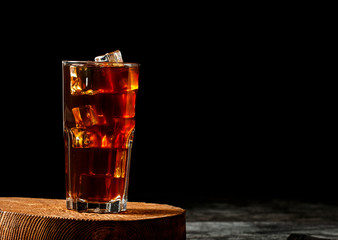 Iced coffee with milk on a dark background. Coffee with ice and cream on a gray background close-up.
