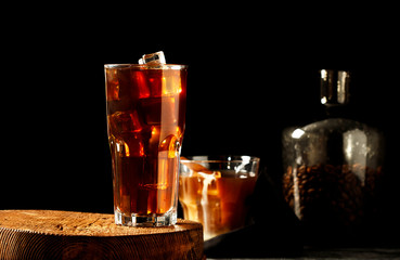 Iced coffee with milk on a dark background. Coffee with ice and cream on a gray background close-up.