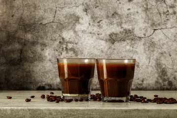 Iced coffee with milk on a dark background. Coffee with ice and cream on a gray background close-up.