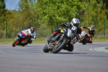 Road racing motorcykel in high speed into a curve, panning shot