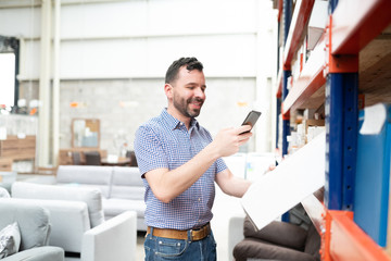 Fototapeta premium Handsome Male Customer Using Mobile Phone While Shopping