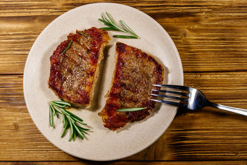 Grilled pork steaks with rosemary on wooden table. Top view