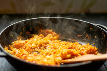 Fry onions and carrots in a pan.