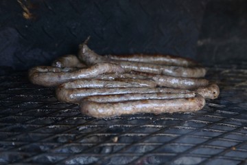 Traditional South African boerewors being cooked on a braai grill. 