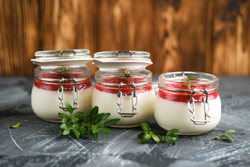 Classic italian dessert creamy panna cotta with cherry sauce on a dark rustic background copy space.