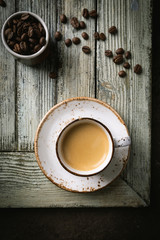 Top view cup of hot coffee with roasted coffee beans on wooden table background
