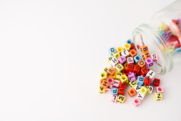 Small coloring alphabet cube with glass bottle and white as background. Education Concept.