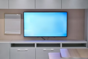 Tv room with bright interior and glowing blue light of LCD screen