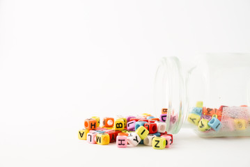 Small coloring alphabet cube with glass bottle and white as background. Education Concept.