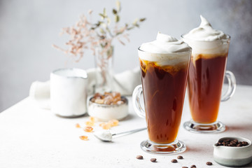 Iced coffee in a tall glasses with cream poured over