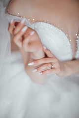 Wedding concepts, details, ideas and themes. Young bride is going to a wedding. Morning of the bride. Details, accessories. The bride is waiting for a meeting with groom. Beautiful bride. 
