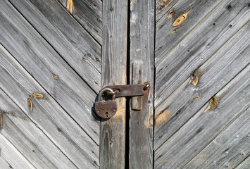 Grungy grey color wooden door with lock.