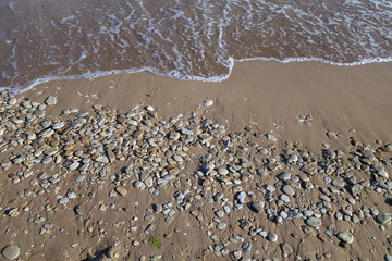 Small stones sand and sea wave.