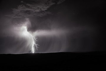 Bolt of lightening striking the ground at night