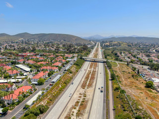 Aerial view of highway surrounded by villa in suburb. Intersection city transport road with vehicle movement. California, USA.