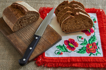 bread with knife and fork on wooden board