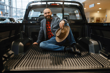 Smiling man poses in the back of new pickup truck