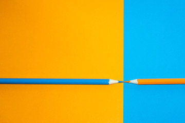 Orange and blue pencil facing each other. Minimal Aesthetic.