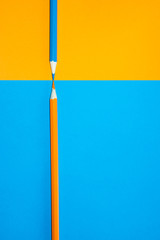 Orange and blue pencil facing each other. Minimal Aesthetic.