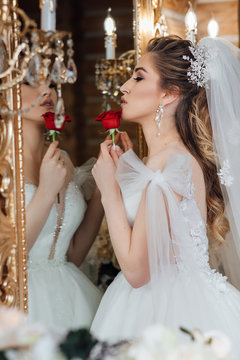 Gorgeous bride. Perfect Make up. Hairstyle, wedding jewelry.The bride reflects in the mirror. 