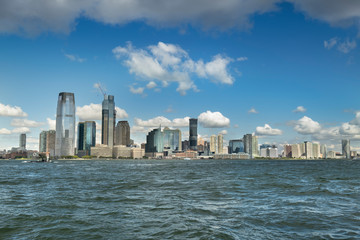 Skyline cityscape view from Battery Park of the office buildings and skyscrapers over the Hudson River waterfront of New Jersey USA