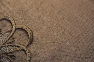 Fototapeta na wymiar Linen beige background with lace. The thread direction is diagonal. The texture of the linen fibers.