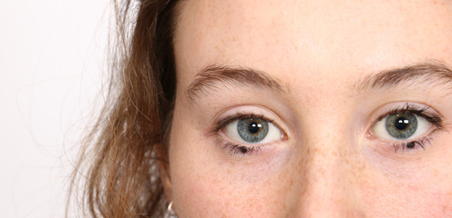 Studio closeup portrait of blue eyed fair skinned young woman wearing minimal make up