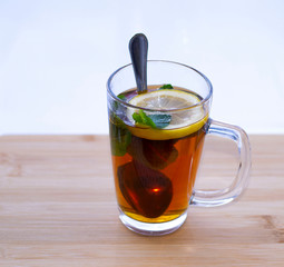 morning tea in a transparent glass with lemon and mint befor window