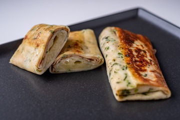 delicious healty pancakes with spinach and chease  on blac plate