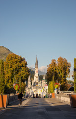 Lourdes, France - 09/29/2019: road to Sanctuary of Our Lady in Lourdes, France. Famous religious centre of pilgrims. Aerial view of cathedral with basilica on mountains background. Spiritual travel.