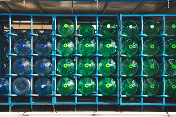 Bidones de agua mineral, botellones de plástico, verde y azul, dentro de un camion.