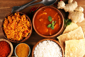 Chicken tikka masala spicy curry meat food in pot with rice and naan bread. indian food on table