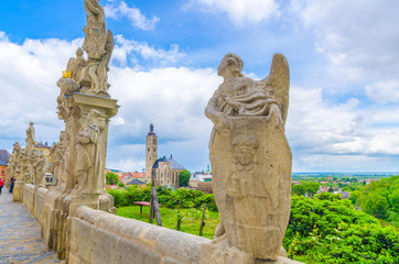 Fototapeta na wymiar Baroque statues of saints and the Church of St James catholic church building with clock tower background in Kutna Hora historical Town Centre, Central Bohemian Region, Czech Republic