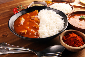 Chicken tikka masala spicy curry meat food in pot with rice and naan bread. indian food on table