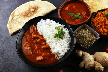 Chicken tikka masala spicy curry meat food in pot with rice and naan bread. indian food on table
