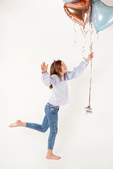 Funny girl with cats ears holding balloons in studio. Concept birthday