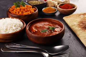 Chicken tikka masala spicy curry meat food in pot with rice and naan bread. indian food on table