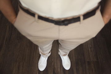 Man corrects belt, fees groom, man's hands, dressing, man buttons pants, jeans