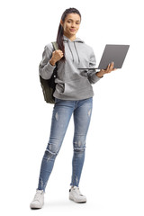 Female student with backpack holding a laptop computer and smiling at the camera - obrazy, fototapety, plakaty