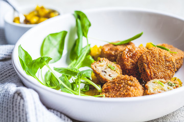 Vegan vegetable meatballs with spinach and green dressing.