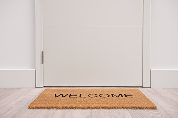 White door with a welcome mat - obrazy, fototapety, plakaty