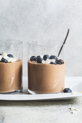 Chocolate mousse (smoothie) with berries and coconut in glass for breakfast.