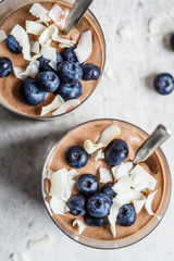 Chocolate mousse (smoothie) with berries and coconut in glass for breakfast, top view.