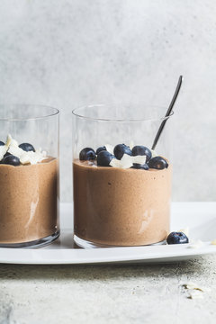 Chocolate mousse (smoothie) with berries and coconut in glass for breakfast.
