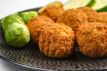 Cooking of healthy vegetarian food, tasty check pea falafels and frehs green vegetables