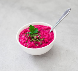 Russian appetizer horseradish with beetroot in a bowl in rustic style on a light background